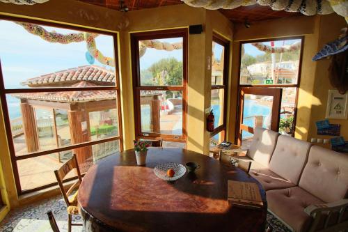 a living room with a table and a large window at Villa Ana Margarida Beach in Ericeira