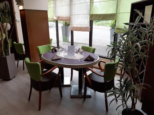 a table and chairs in a room with a window at Kyriad Hotel Nevers Centre in Nevers