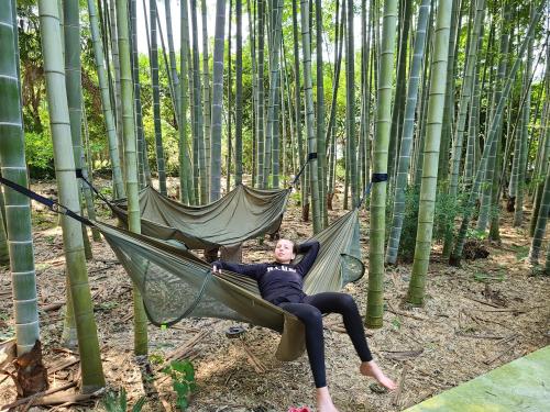 a woman laying in a hammock in a bamboo forest at あかがね荘 in Sumino