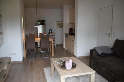 een woonkamer met een tafel en een bank en een keuken bij Haus Wanderlust in Willingen