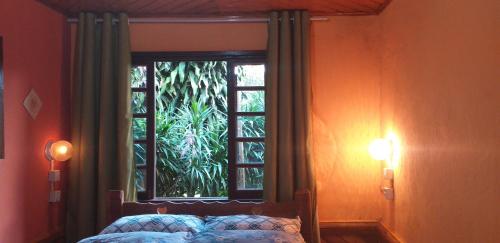 une fenêtre dans une chambre avec un lit et une fenêtre avec dans l'établissement Chalés Vale Verde, à Visconde de Mauá
