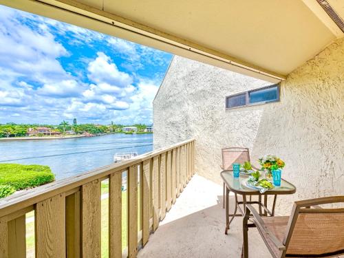a balcony with a table and chairs and a view of the water at Luxury Waterfront Views - Heated Pool - 1400sf Duplex - Minutes to the Beach in Siesta Key