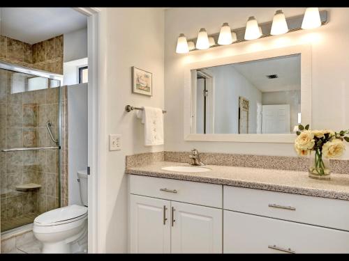 a bathroom with a sink and a toilet and a mirror at Luxury Waterfront Views - Heated Pool - 1400sf Duplex - Minutes to the Beach in Siesta Key