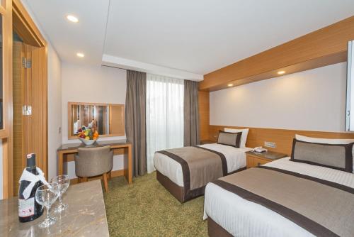イスタンブールにあるビセタン ホテルのベッド2台とデスクが備わるホテルルームです。