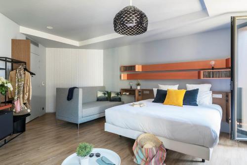 a bedroom with a large bed and a chair at Golden Tulip Saint Malo– Le Grand Bé in Saint Malo