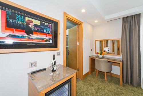 a room with a tv and a desk with a chair at Bisetun Hotel in Istanbul