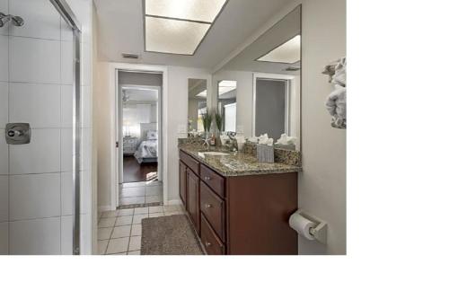 a bathroom with a sink and a large mirror at Villa Flannie in Cape Coral