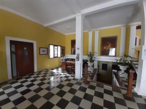 Cette chambre dispose d'un sol en damier et de murs jaunes. dans l'établissement Villa Carolina Bed and Breakfast, à San Felipe de Puerto Plata