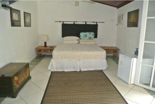 ein Schlafzimmer mit einem Bett in einem weißen Zimmer in der Unterkunft Pousada Lele do Pero in Cabo Frio