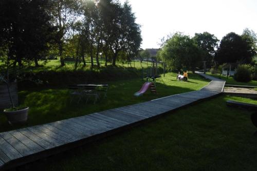 Una pasarela en un parque con un perro en el césped en Ruegen Fewo 66, en Kasnevitz