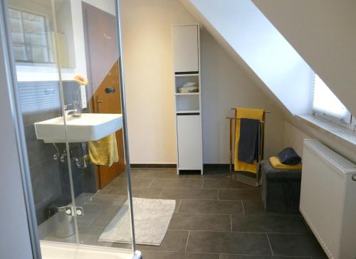 ein Badezimmer mit Waschbecken und Glasdusche in der Unterkunft Daun Under in Daun
