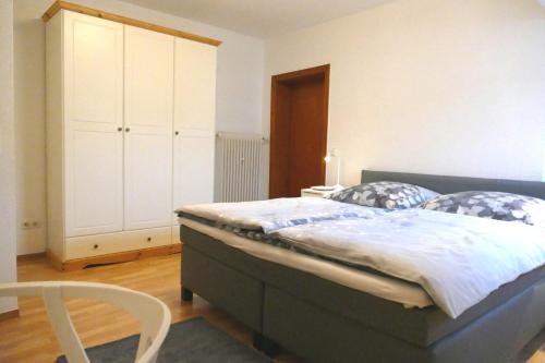 1 dormitorio con 1 cama grande y armario blanco en Daun Under, en Daun