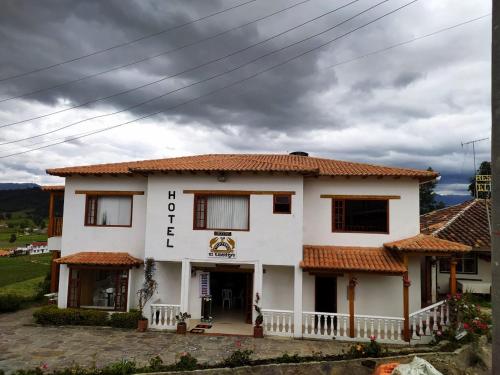 un edificio blanco con techos de baldosas rojas en Hotel El Cangrejo, en Paipa