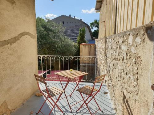 a table and two chairs sitting on a balcony at Suite privé dans maison de village in Soual