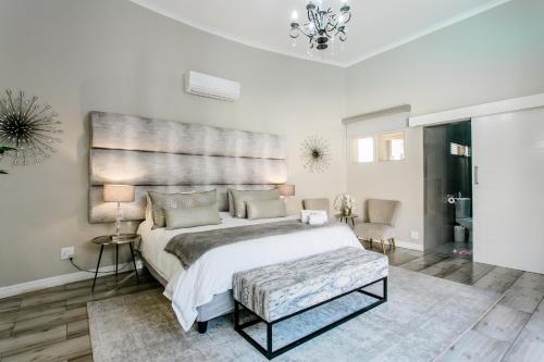 a bedroom with a large bed with a large headboard at Stonehill Villa in Bloemfontein