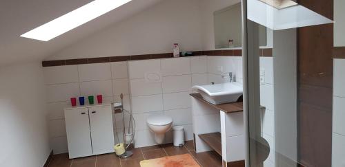 uma casa de banho branca com um lavatório e um WC em Apartment Claudia em Gröbming