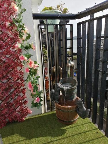 a bird bath on a balcony with a water fountain at Roneragh Apartments Paul's place The Only Penthouse Apartment in Fahan