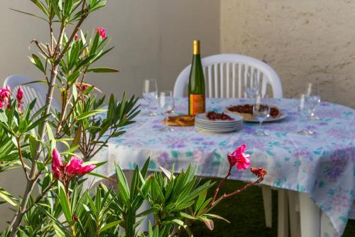 una mesa con una botella de vino y un plato de comida en MA ROSE DES LUMIERES maison indépendante 6 personnes avec grande cour en Griesheim-près-Molsheim