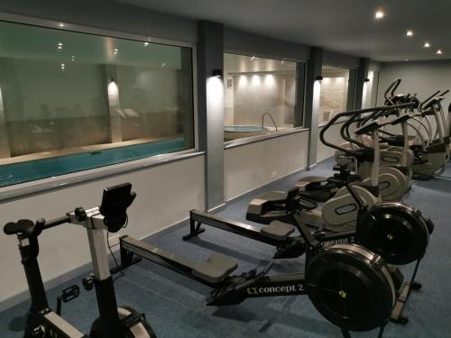 a gym with several exercise bikes and a swimming pool at The Beeches Hotel & Leisure Club in Nottingham