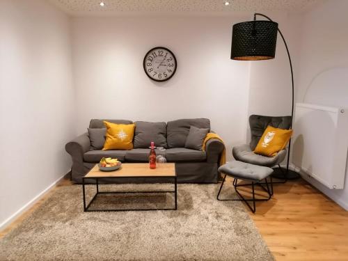 a living room with a couch and a clock on the wall at Ferienwohnung Seebär in Emden