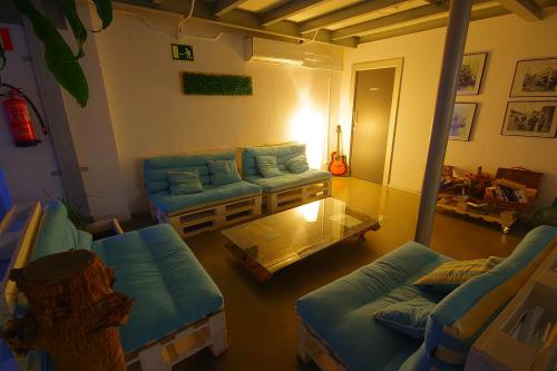 a living room with blue couches and a table at All Iron Hostel in Bilbao