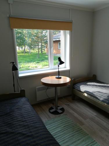 a room with a table and a window and a bed at Remniku Holiday Centre in Remniku