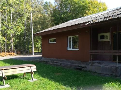 a brown building with a bench in front of it at Remniku Holiday Centre in Remniku