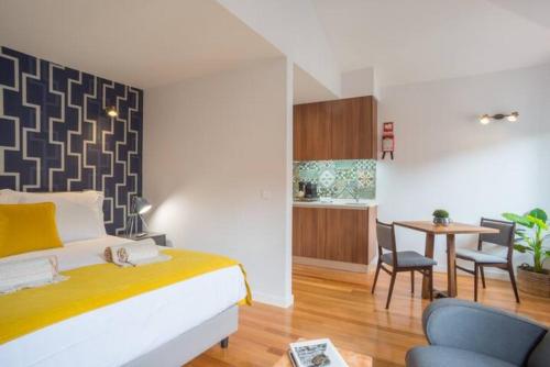 a bedroom with a bed and a table with chairs at TMH Torrinha in Porto