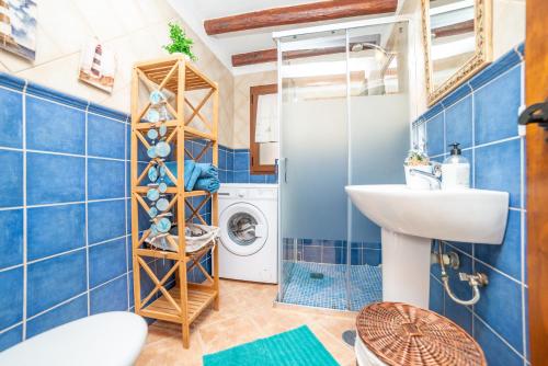 ein blau gefliestes Bad mit einer Waschmaschine und einem Waschbecken in der Unterkunft Casa la Orilla in Antigua