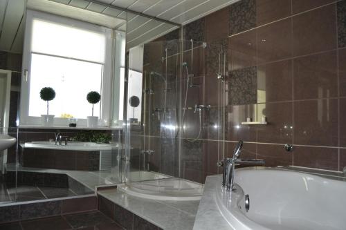a bathroom with a tub and a sink and a window at Penthouse Himmelreich großzügige Maisonette auf 152 qm mit Klima & Kamin in Senftenberg
