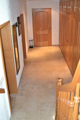 a hallway with wooden doors and a floor with a staircase at Penthouse Himmelreich großzügige Maisonette auf 152 qm mit Klima & Kamin in Senftenberg