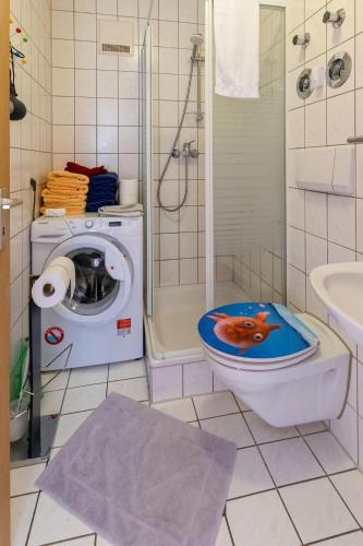 a bathroom with a toilet with a dog on the lid at Ferienwohnung Big Family in Ichenhausen