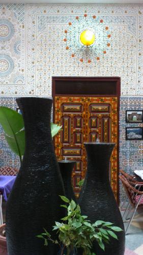 two black vases sitting in front of a wall at Ryad Bab Berdaine in Meknès