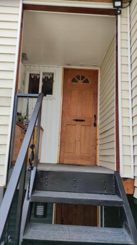 a front door of a house with a staircase leading to it at Departamento Cabaña amoblada Puerto Montt in Puerto Montt