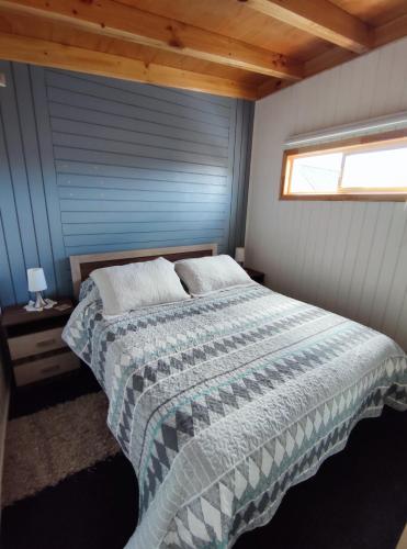 a bedroom with a bed with a blue wall at Departamento Cabaña amoblada Puerto Montt in Puerto Montt