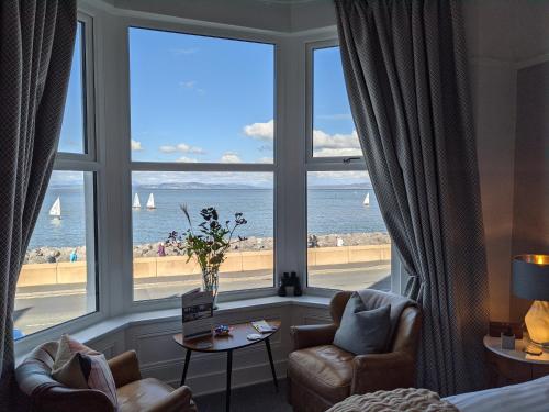 a room with a large window with a view of the ocean at The Broadwater Guest House in Morecambe