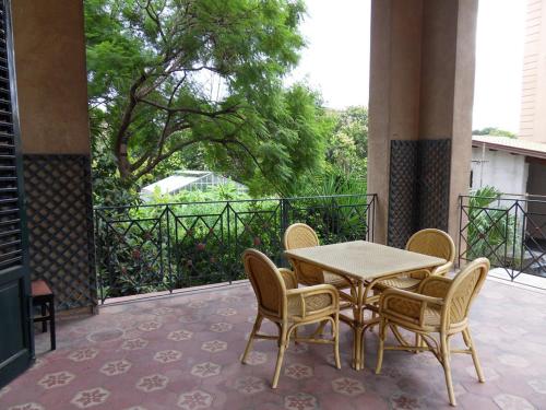 a patio with a table and chairs on a balcony at Hotel Villa Archirafi in Palermo