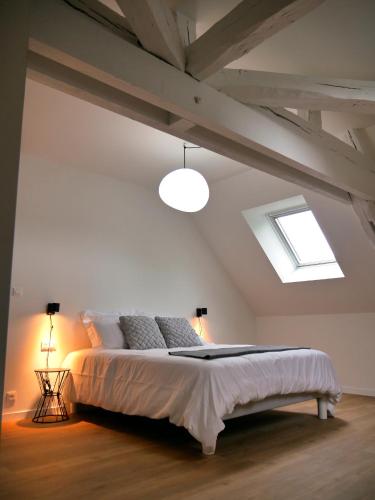 ein Schlafzimmer mit einem großen Bett im Dachgeschoss in der Unterkunft KastellRen - Maison d'hôtes in Rennes