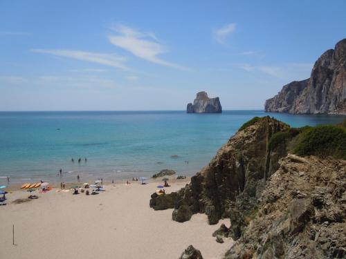 a group of people on a beach near the ocean at Bobo’s Home in Iglesias