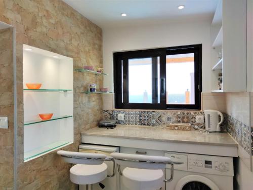 a laundry room with a washer and a window at 7. Luxurious sea view rooftop suite in the center! in Rhodes Town