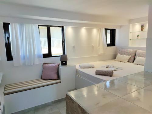 een woonkamer met 2 bedden en een bank bij 7. Luxurious sea view rooftop suite in the center! in Rhodos-stad