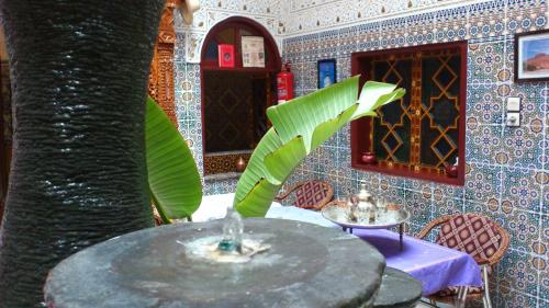 a dining room with a table and a tree at Ryad Bab Berdaine in Meknès