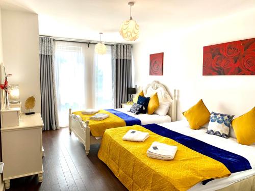 duas camas num quarto com amarelo e azul em 2-Bedrooms Apartment, Lounge, Balcony em Londres