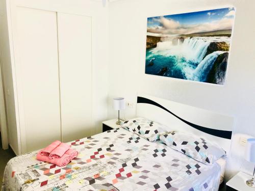um quarto com uma cama e uma imagem de uma cascata em Apartamento Santa Pola"The Guitar" 300 m de la playa em Santa Pola