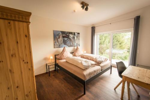 ein Schlafzimmer mit einem Bett mit Kissen darauf in der Unterkunft Nürburgring Aparts in Welcherath