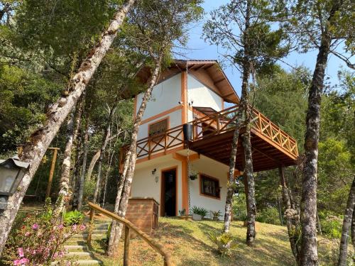 モンテ・ヴェルデにあるCapricho da Natureza Pousadaのバルコニー付きの森の家