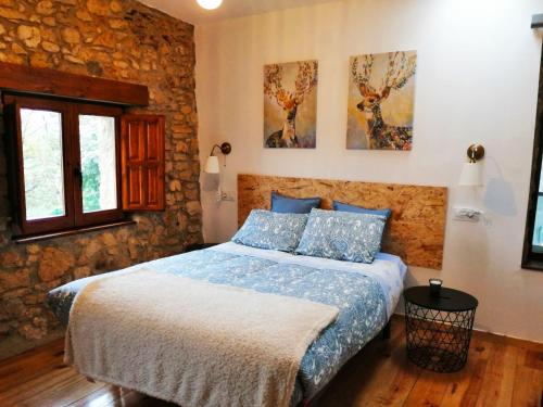 1 dormitorio con 1 cama en una pared de piedra en El llagar - Sagasta Rural Oviedo, en Oviedo