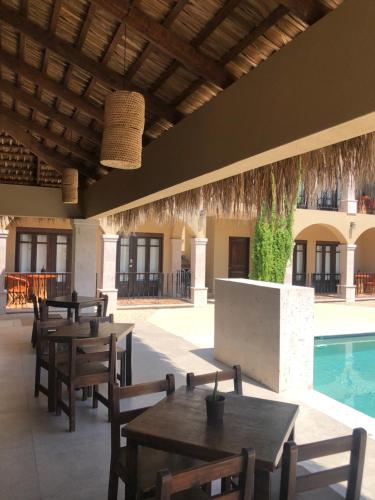 a patio with tables and chairs and a swimming pool at Hotel 1697 Loreto in Loreto