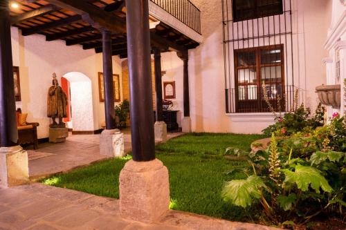 a porch of a house with a green yard at Las Cruces Boutique Hotel in Antigua Guatemala