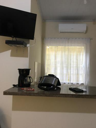 eine Küchentheke mit einem Telefon und einem Fenster in der Unterkunft Descanso do Jordão in Abraão